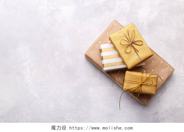 灰色石头背景的金色礼品盒金色礼品盒